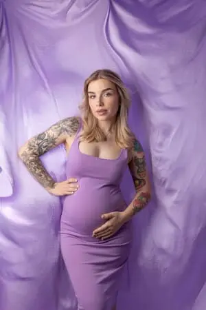 Femme enceinte avec la main sur le ventre, en ton violet.
