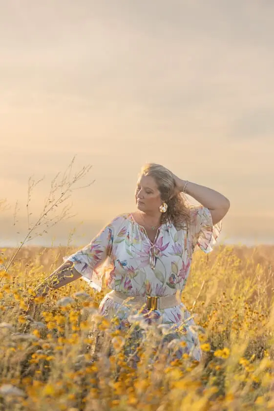 Femme dans un champ de blé au coucher du soleil.