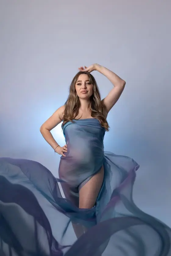 Femme enceinte en portrait dans les tons bleus lors d’une séance photo grossesse au studio.